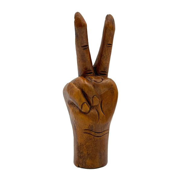 Wooden hand making a peace sign on a white background