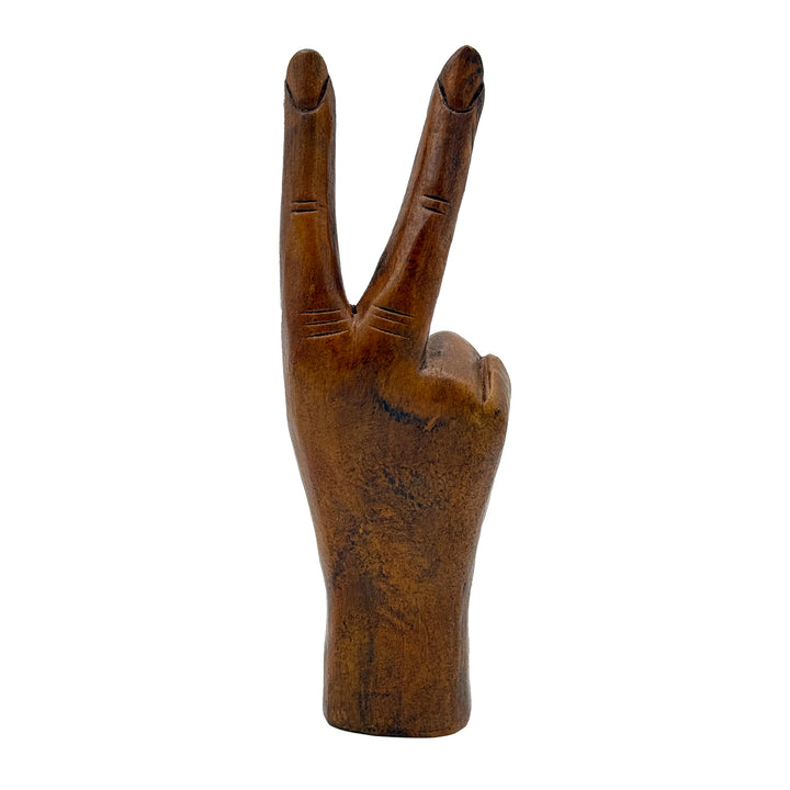 Wooden hand making a peace sign on a white background